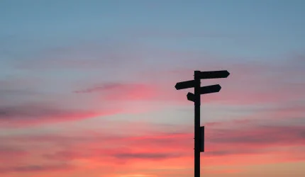 Image depicting a signpost with multiple direction signs at sunrise