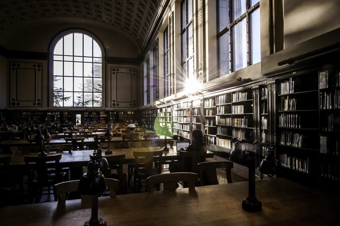 The sun shines through the windows of Doe Library’s North Reading Room.