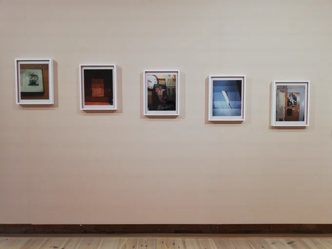 5 framed photographs are on a white wall. From left to right, each frame is slightly lower on the wall than the previous one. 