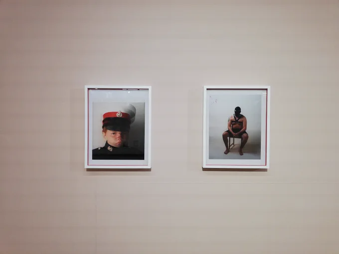 2 photographs in white frames are hanging on a white wall. 