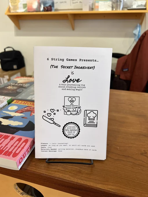 A closeup of our black and white zine, The Secret Ingredient Is Love