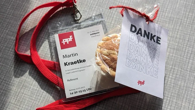 Ein Namensschild des pub&print Forums und eine eingeschweißte Leipziger Lerche mit einem Dankeschön-Kärtchen