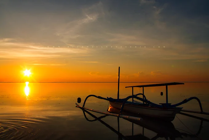 Sunset view with the boat on right, Sanur Beach of Bali, Indonesia

www.rrcreativity.com