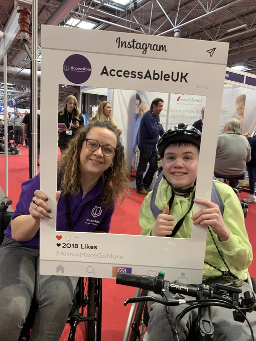 Carrie Ann Lightley and an AccessAble Ambassador take a selfie with a cardboard cutout at Naidex