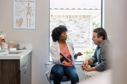 Doctor and patient in a medical office, talking during an appointment. 