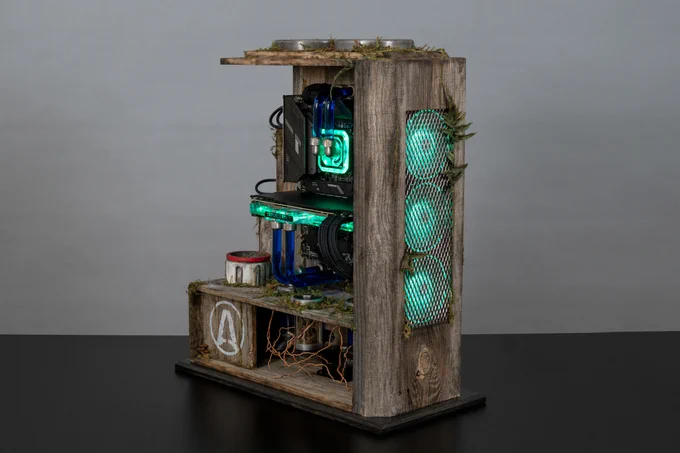 Photo of the Terra Nil Custom PC. It has a wooden cabinet structure, moss leaves, green LED lights, and figures of Terra Nil structures decorating the exterior and interior. 