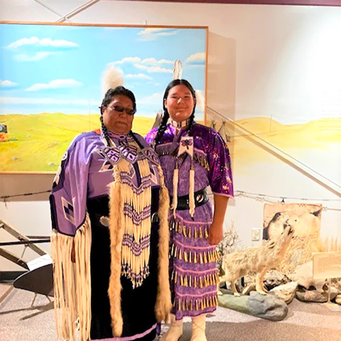 Lita and Catherine stand together wearing cultural clothing for their performance of a First Nation Jingle Dance 