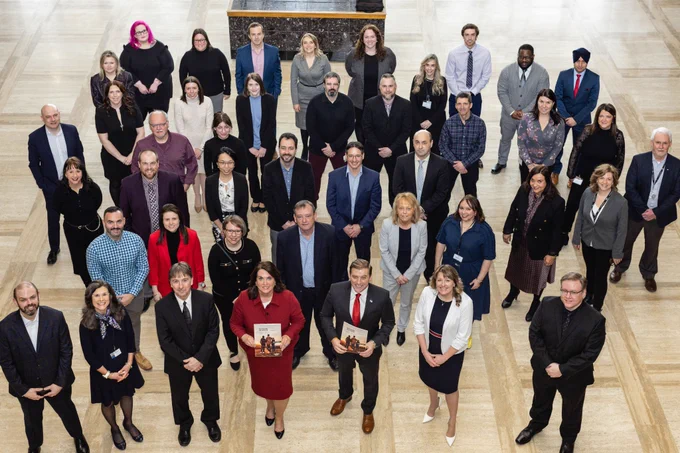 Large group photo of the hard-working folks involved in Budget 2023 standing in the lobby of the East Block of Confederation Building. 