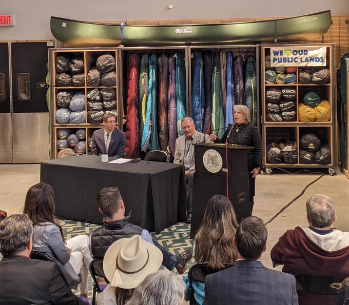 Photo of the governor speaking at a podium at REI