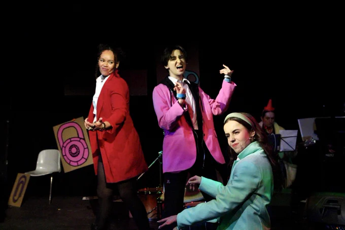 The band rock out on imaginary instruments.