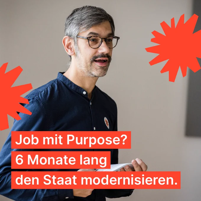 Ein Mann mit grau­me­liert Haaren präsentiert einen Vortrag. Dabei hält er Moderationskarten in der Hand. Auf dem Foto die Aufschrift: Jom mit Purpose? 6 Monate lang den Staat modernisieren. 
