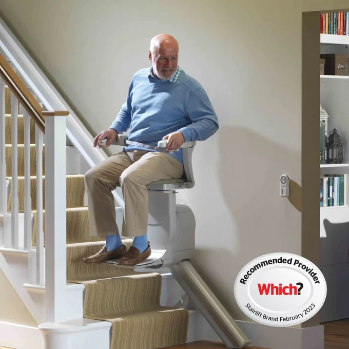 A man using Stannah stairlift to get upstairs - Which? Recommended Provider logo 