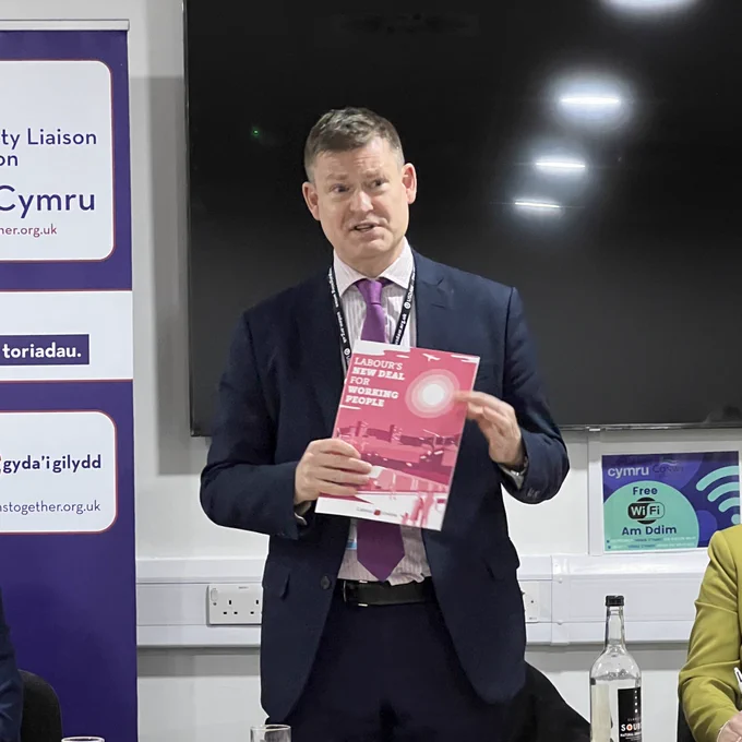 Justin Madders holding up a printed copy of Labour’s new deal for working people