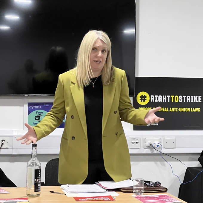 Hannah Blythyn speaking in front of a labour unions board that says right to strike oppose and repeal anti-union laws
