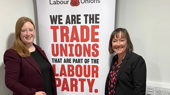 Jen and Jo standing next to a banner that says we are the trade unions that are part of the Labour Party