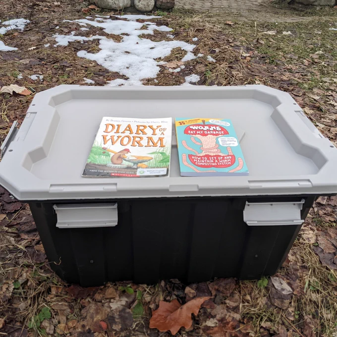 Large bin with snap on lid with two worm-related books on top. 
