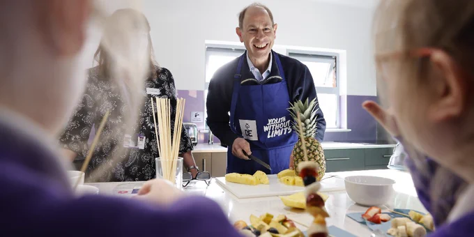 The Duke, smiling whilst cutting up fruit with young people at a recent visit to Blackpool. 