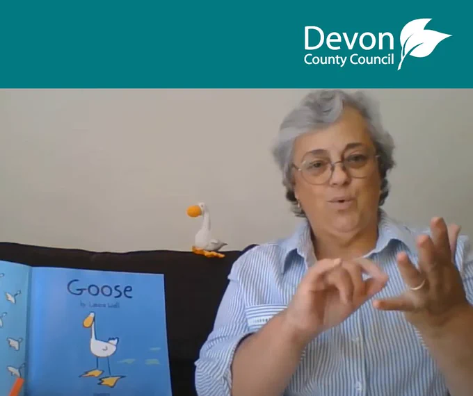 Devon County Council logo and Debra May, Deaf Inclusion Worker signing the story 'Goose' in BSL