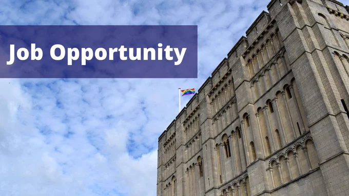 A photograph of Norwich Castle which is a square building full of windows and a LGBTQ  flag flying at the top. The castle is on the right side of the image with blue cloudy skies on the left. There is a blue box which in white writing over it says 'Job Opportunity'.