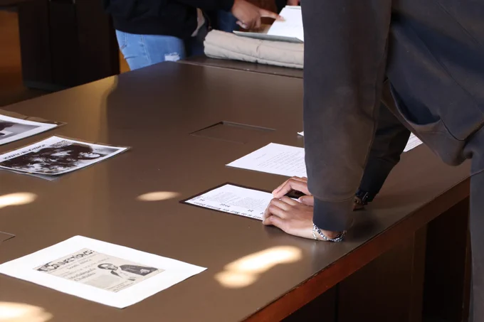 Documents on a table with two people looking at them