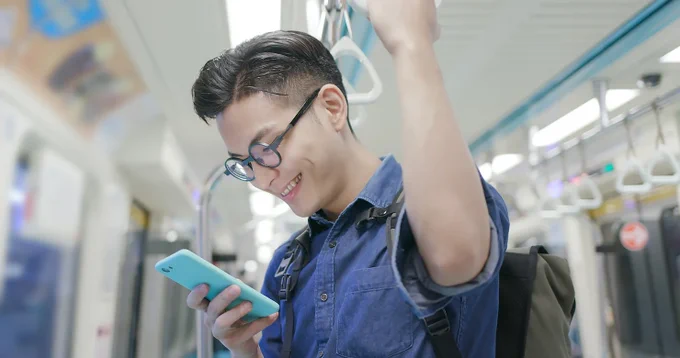 homme qui regarde son téléphone dans les transports en commun 
