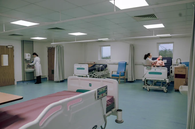 Photo of the Porton Down hospital ward, with two female scientists at work. 