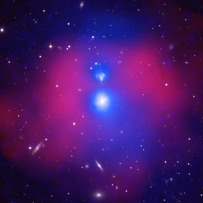 This image of NGC 6338 contains X-ray data from Chandra, in red, that shows hot gas as well as cooler gas detected with Chandra and XMM-Newton, in blue. Two blue regions surround white cores. The blue regions resemble two round pieces of a snowman stacked on one another, almost touching, with the larger snowball on the bottom. Surrounding the blue regions, more strongly on the left and the right, are somewhat transparent red clouds. Many galaxies and stars of varying sizes, shown in optical light from the Sloan Digital Sky Survey, are scattered throughout the image and can be viewed even where the blue and red clouds are present.