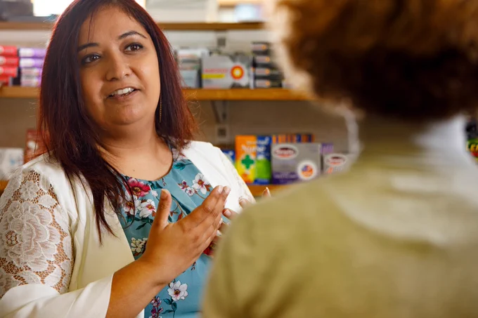 Community pharmacist in conversation with a patient