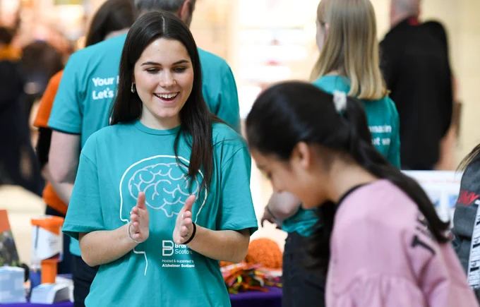 A female scientist talks to a member of the public at a science engagement event