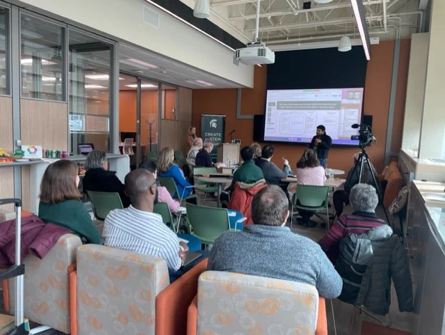 Photo from the back of the room in CREATE seminar series facing front - shows audience backs with speaker's facing front at head of room. 