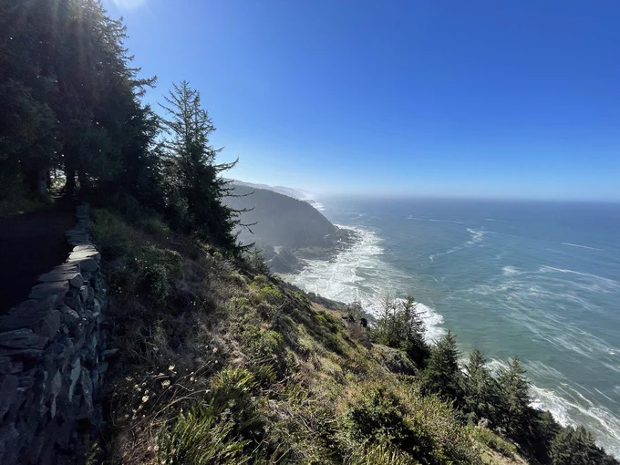The coast stretches on to the South. Waves come up against the rocky shore. 