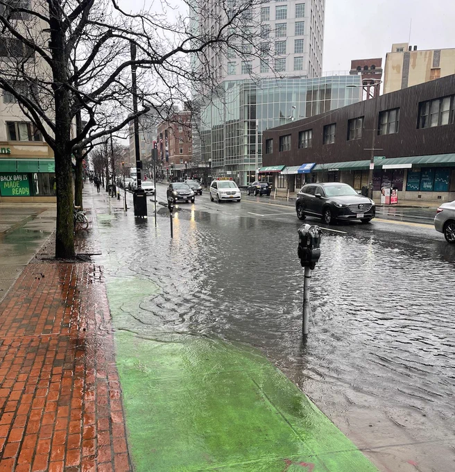 Massachusetts Ave in Boston with an enormous puddle covering a car travel lane and the bike lane. 