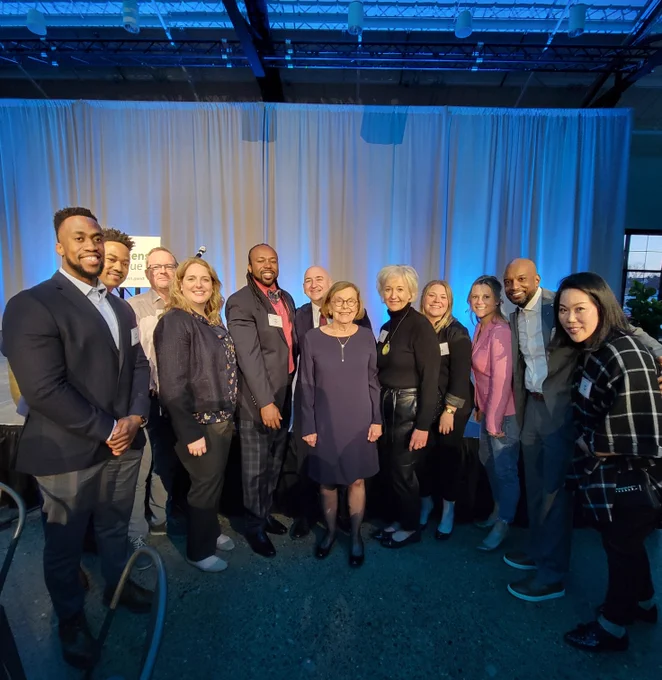 Team photo of employees and honored guest in middle