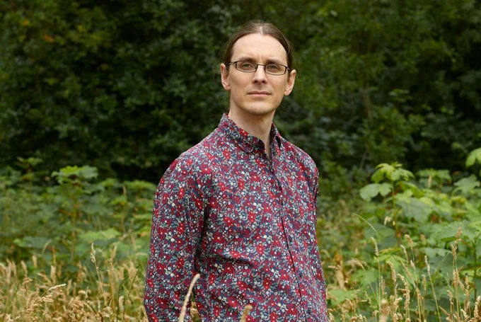 CTO/co-founder Roelof Pieters standing in a field while wearing a floral button-down shirt