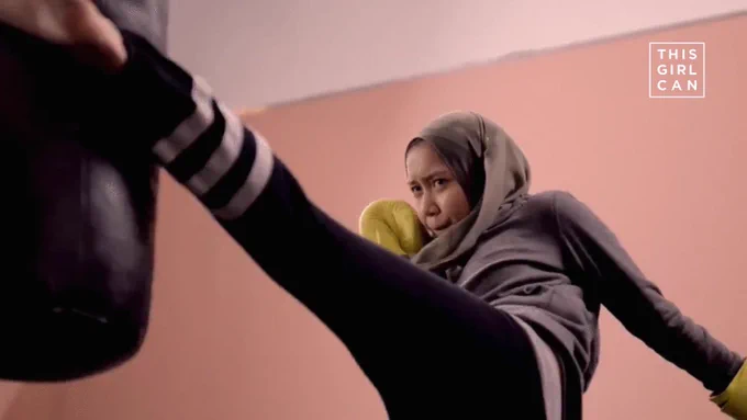 The image shows Fakhira kickboxing, kicking a punchbag. The This Girl Can logo is in the top right-hand corner.