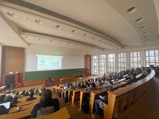 Photo of Ben Hurdelhey presenting at the BTW conference at the TU Dresden.
On the left, the logo of the best database in the world can be seen.