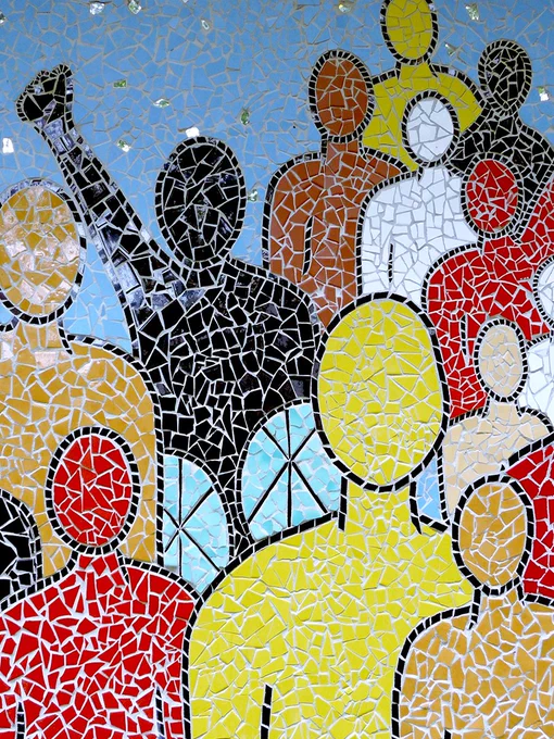 A tiled mosaic of figures composed of various colours. A figure composed of black tiles has a fist raised. 

