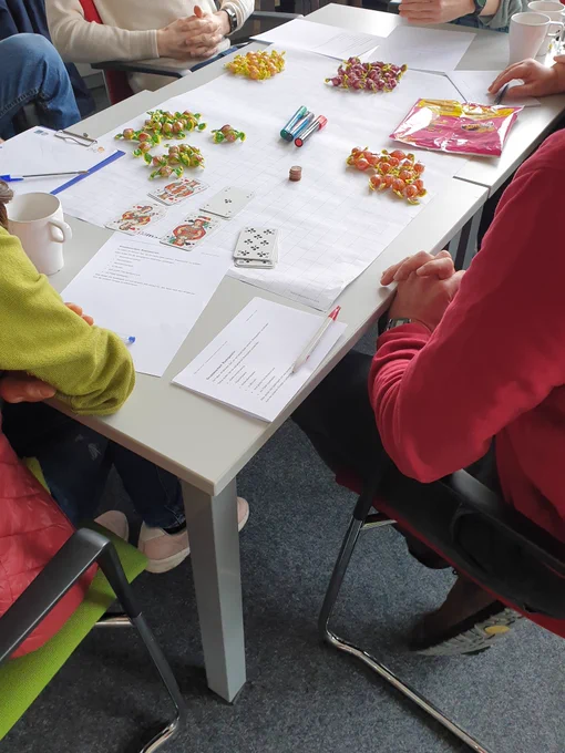 Tisch mit Bonbons, Stiften, Spielkarten