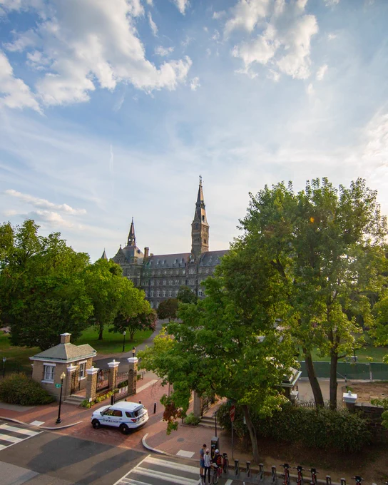 An aerial image of Healy Hall from across the street. The trees surrounding Healy are all covered in green leaves.
