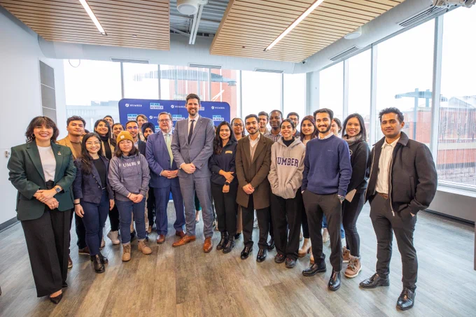 Minister Sean Fraser and MP James Maloney stand with a group of Humber students at Humber Lakeshore Campus