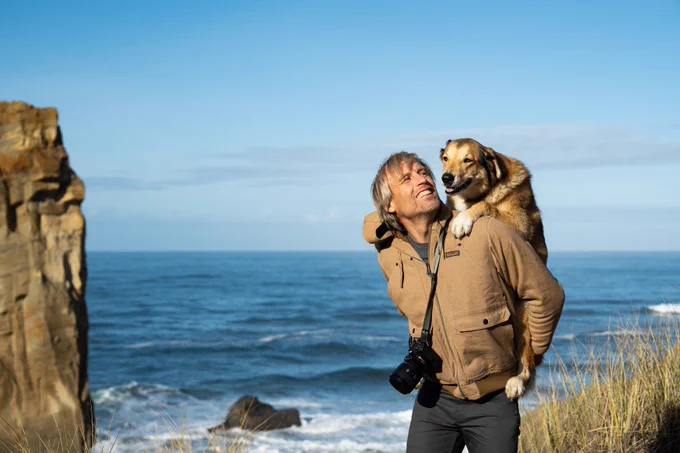 Ben Moon carrying his dog on his back.