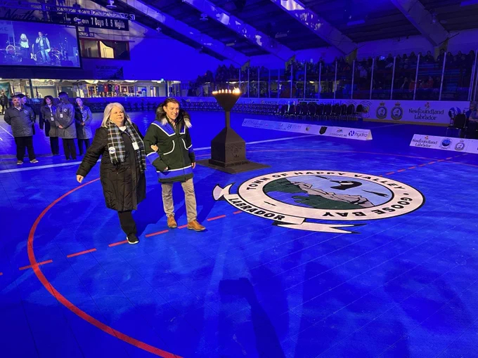 Premier walks with organizing committee member in the arena at Labrador Winter Games closing