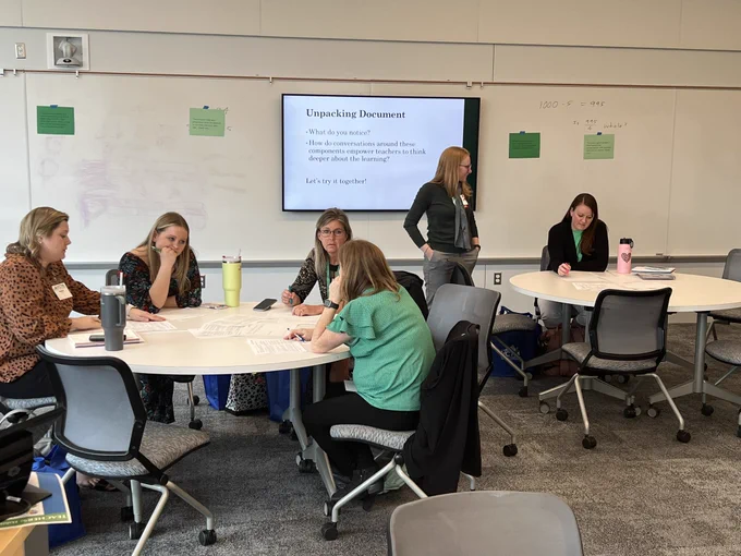 Teachers at round tables talking.