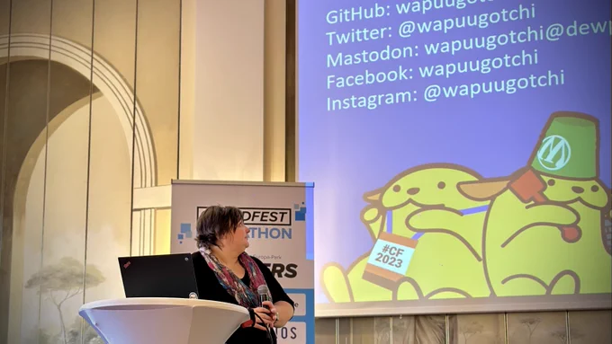 Birgit is presenting on the Hackatjon stage. In the background, you see a slide of the presenting.
