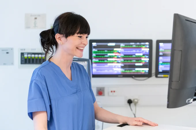 Photograph of a hospital matron reading from her computer screen.