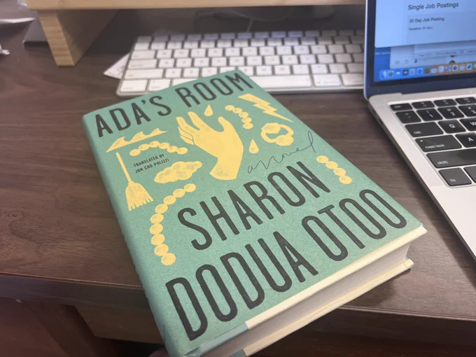 The cover of the novel Ada’s Room by Sharon Dodua Otoo, translated by Jon Cho-Polizzi. It’s a green cover with several objects in gold: pearls, a hand, a broom, a door knocker and a lightening bolt.