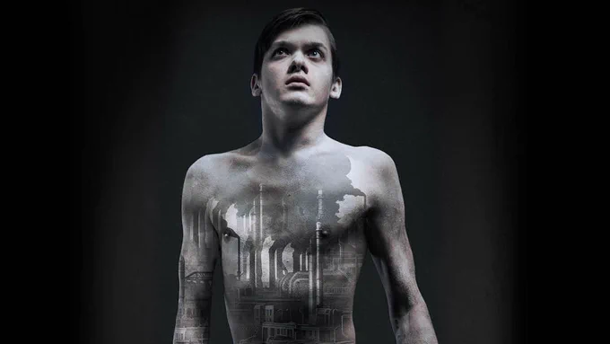 A photo showing a man daubed in grey paint