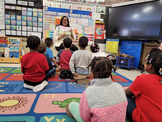 Minnesota Department of Education Deputy Commissioner Stephanie Burrage reads to children while visiting Bethune Elementary School in Minneapolis. 