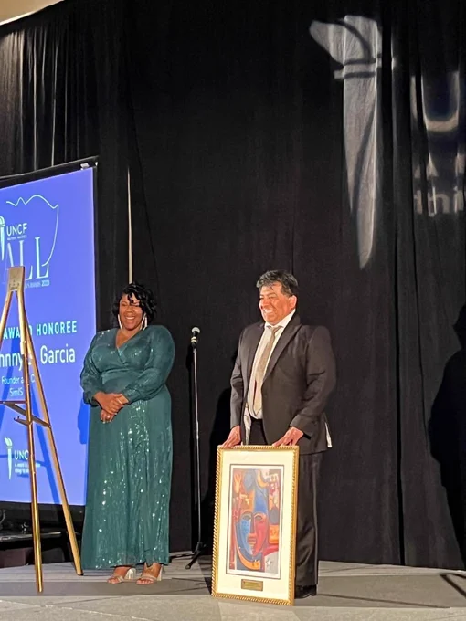 Johnny Garcia on stage with another recipient.