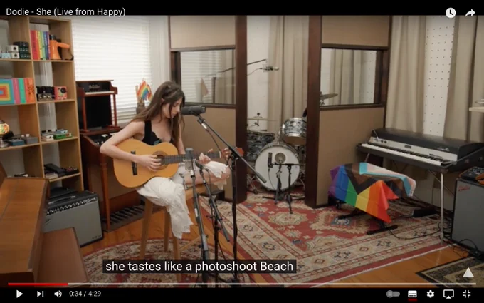 A screenshot from dodie singing 'she' the captions state the lyrics are 'she tastes like a photoshoot Beach' 